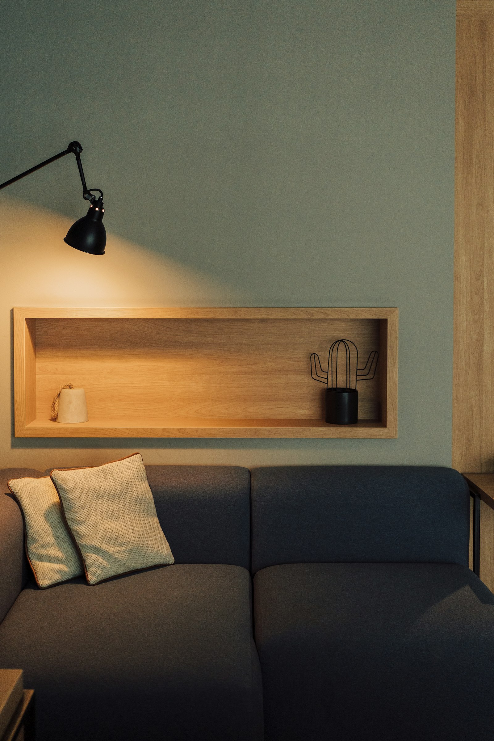 An adjustable wall-mounted reading light above a sofa
